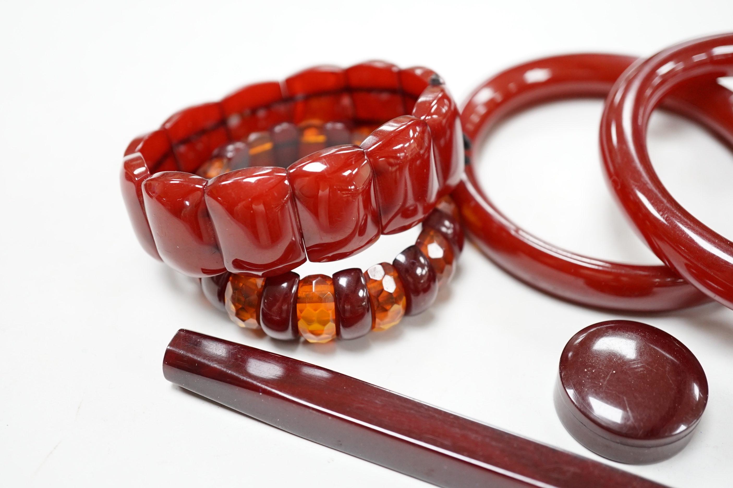Eight simulated cherry amber items including four bangles and two bracelets.